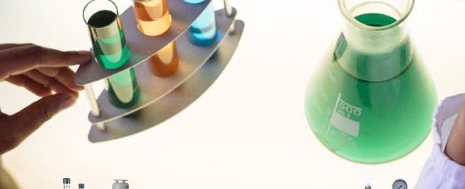 Commonly Used Chemicals in Dosing Pumps 2 chemical dosing laboratory technician examining interaction of chemical compounds