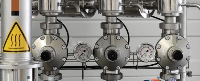 How Does a Metering Pump Work? 5 inside a factory metal plumbing pipes and pressure gauges